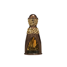 A luxurious perfume bottle for 'Zikra' from the Niche Emarati collection by Lattafa. The bottle has an ornate golden and bronze design, featuring intricate floral patterns at the neck and base. The body of the bottle is translucent, showcasing the amber-c