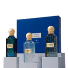 Three perfume bottles with gold caps and blue glass on a white background