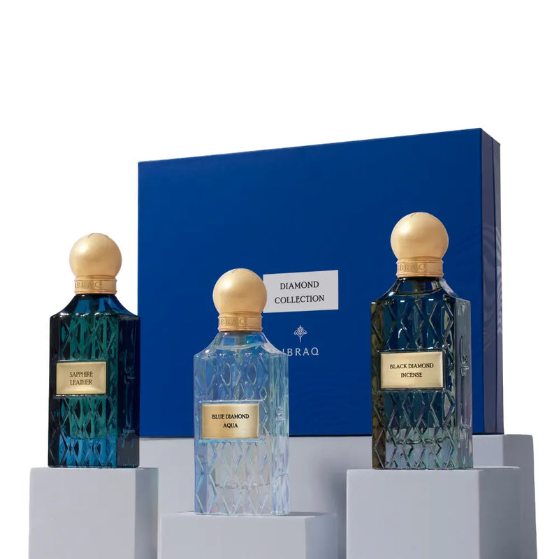 Three perfume bottles with gold caps and blue glass on a white background