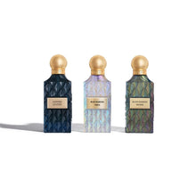Three perfume bottles with gold caps on a white background