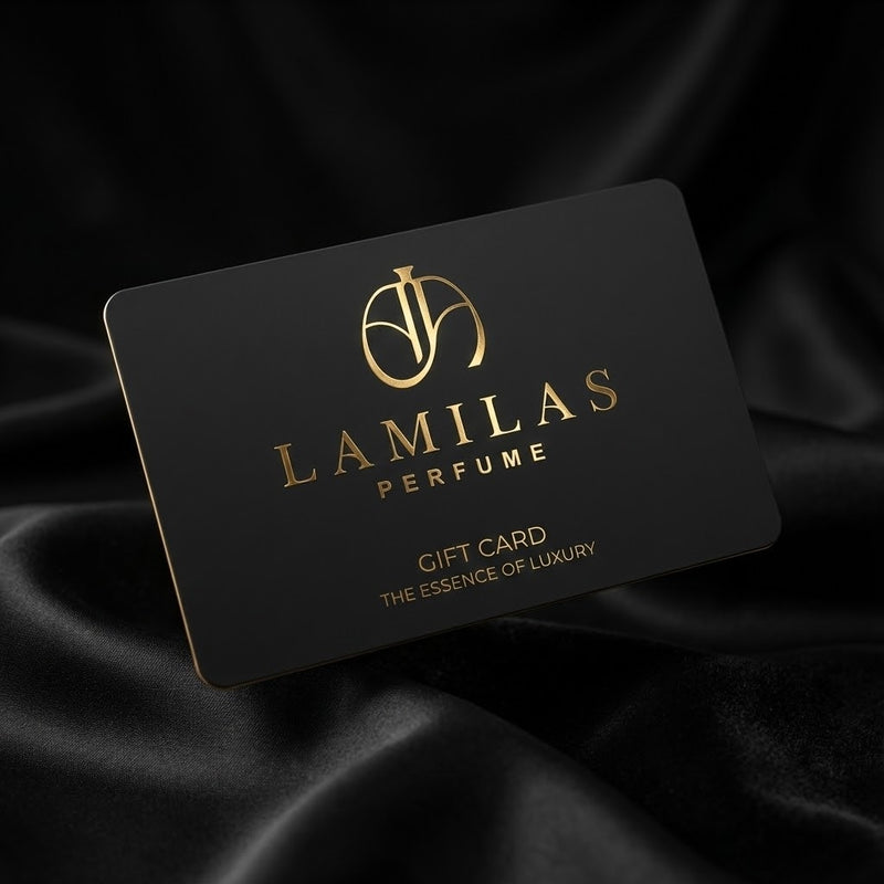 A black "LAMILAS PERFUME" gift card, featuring a gold logo and text, rests on a luxurious black satin fabric.